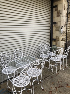 Lot 634 - A pair of glass-topped wrought iron tables in...