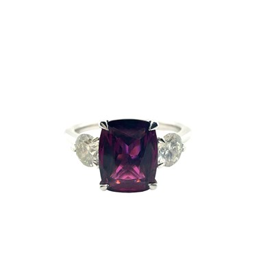 Lot 27 - A three-stone ring set with a cushion step-cut...