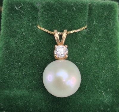 Lot 1004 - A cultured pearl and diamond pendant suspended...