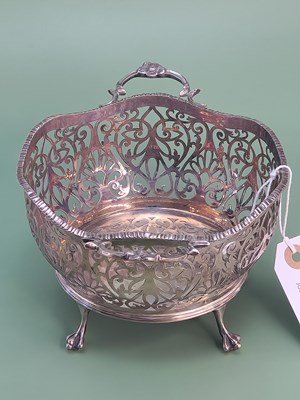 Lot 1409 - A two handled fruit basket on four ball and...