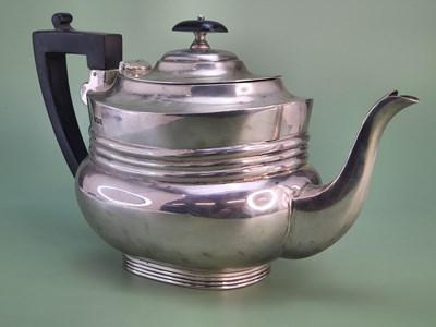 Lot 1418 - A silver tea pot with an ebonised handle and...