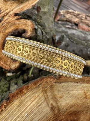 Lot 1077 - An elegant antique hinged bangle of Etruscan...