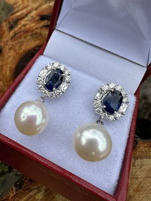 Lot 1071 - A pair of 18ct white gold droplet earrings set...