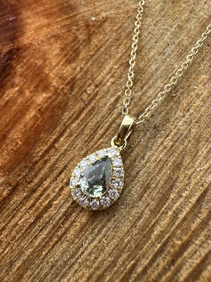 Lot 1072 - An 18ct hallmarked gold pear-shaped green...