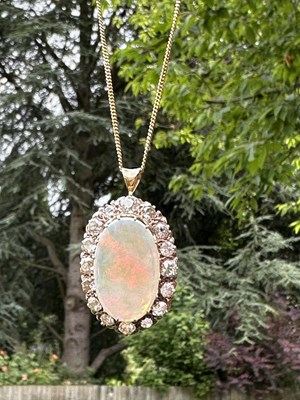 Lot 1008 - A large oval opal pendant in gold...