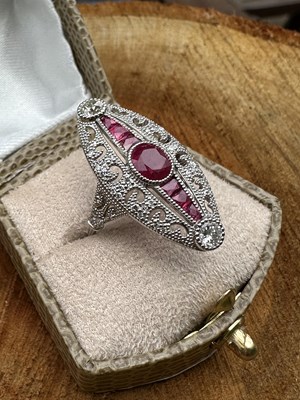 Lot 1106 - A platinum elongated ring set with oval and...