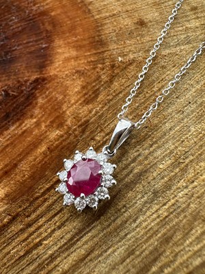 Lot 1125 - An 18ct white gold oval ruby and round...
