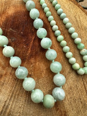 Lot 1097 - Two graduated rows of pale green beads,...