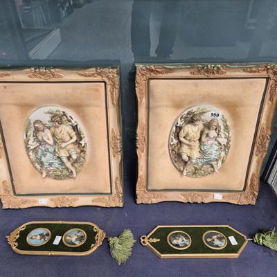 Lot 550 - A framed pair of bisque porcelain relief...