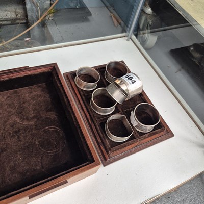 Lot 564 - A velvet lined wooden box of seven silver...