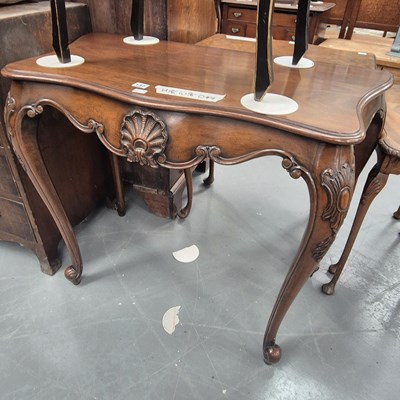 Lot 137 - A serpentine mahogany side table with carved...