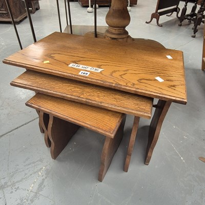 Lot 169 - A vintage nest of three oak tables largest H...