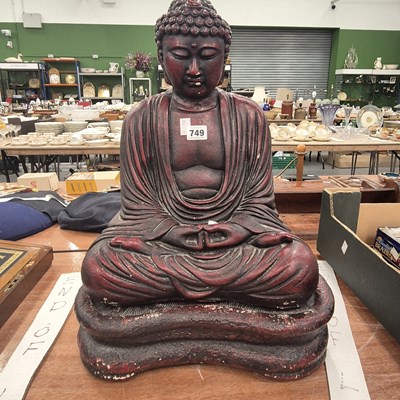 Lot 749 - A red lacquered composition Buddha seated on a...