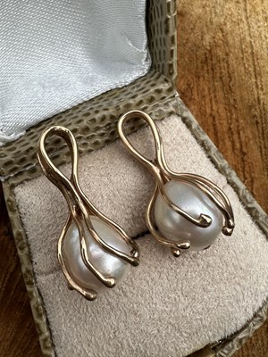 Lot 1176 - Two cultured pearl pendants, each claw-set in...
