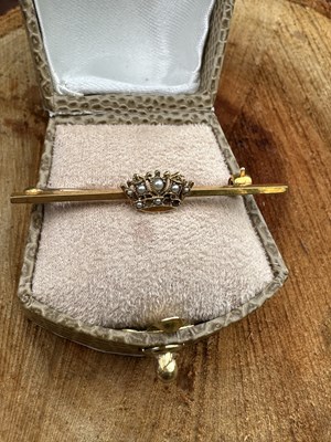 Lot 1191 - A hallmarked 9ct gold bar brooch centred with...