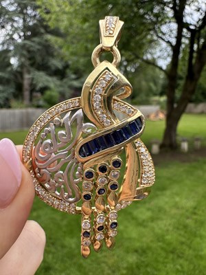 Lot 1252 - A sapphire and diamond pendant of circular...