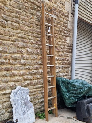Lot 485 - A rustic set of pine extendable ladders with a...