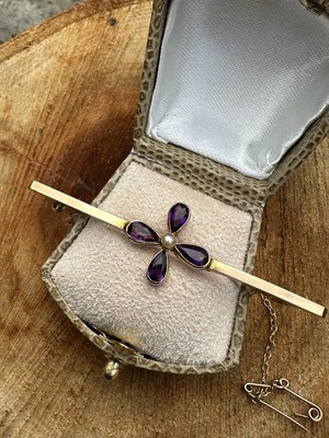 Lot 1085 - An Edwardian amethyst and pearl bar brooch,...