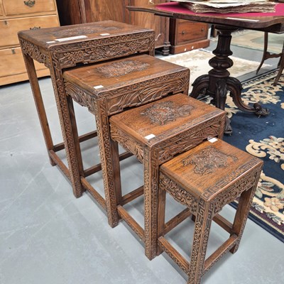 Lot 359 - A nest of four Eastern carved hardwood tables,...