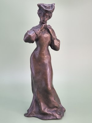 Lot 1583 - An Edwardian bronze figure of a lady standing...