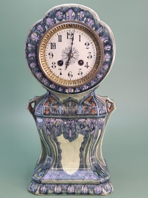 Lot 1816 - An Art Nouveau pottery cased mantle clock...