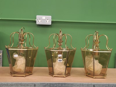Lot 509 - A set of three glazed brass ceiling lanterns