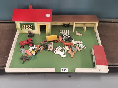 Lot 571 - A toy farmyard with some plastic animals