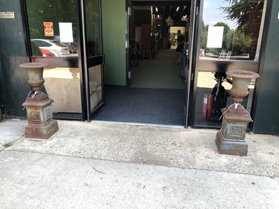 Lot 450 - A pair of cast iron urns on matching plinths...