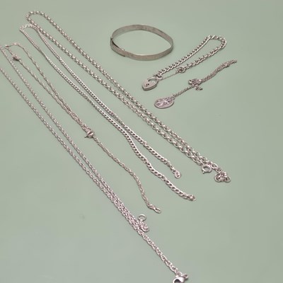 Lot 21 - Four various silver neck chains, a charm...