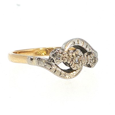Lot 84 - A three-stone diamond crossover ring set with...