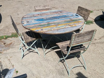 Lot 485 - A rustic circular garden table with four...