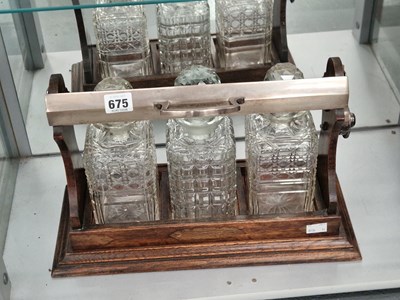 Lot 675 - An oak three bottle tantalus
