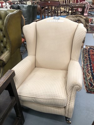 Lot 217 - An early 20th century wing back armchair in a...