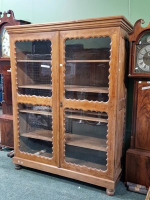 Lot 10 - A European walnut glazed cabinet, the doors...