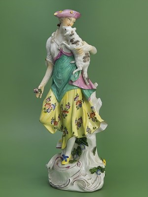 Lot 1880 - A Meissen figure of a shepherdess holding up a...