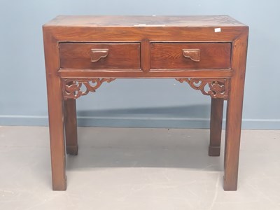 Lot 62 - A Chinese hardwood two drawer table supported...