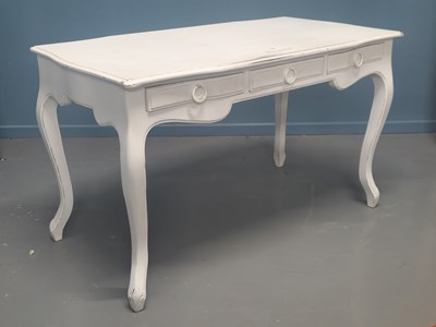Lot 73 - A white painted three drawer table, the...